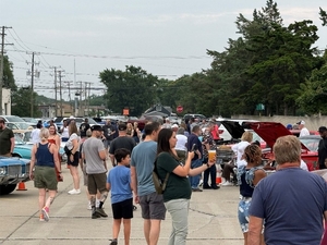 A crowd attends a summer car event.
