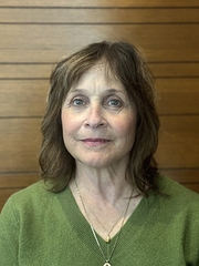A head-and-shoulders photo of a woman with brown hair wearing a green sweater.