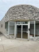 A commercial building with double glass doors and a stone façade.