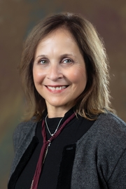 A woman with short brown hair smiles at the camera.