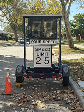 A mobile radar trailer is parked on the street in a residential neighborhood in Oak Park, Michigan